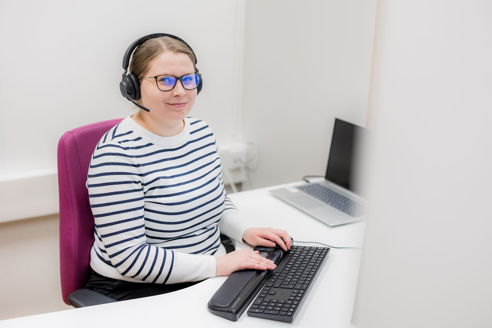 DAS:n palveluneuvoja katsoo kameraa hymyillen